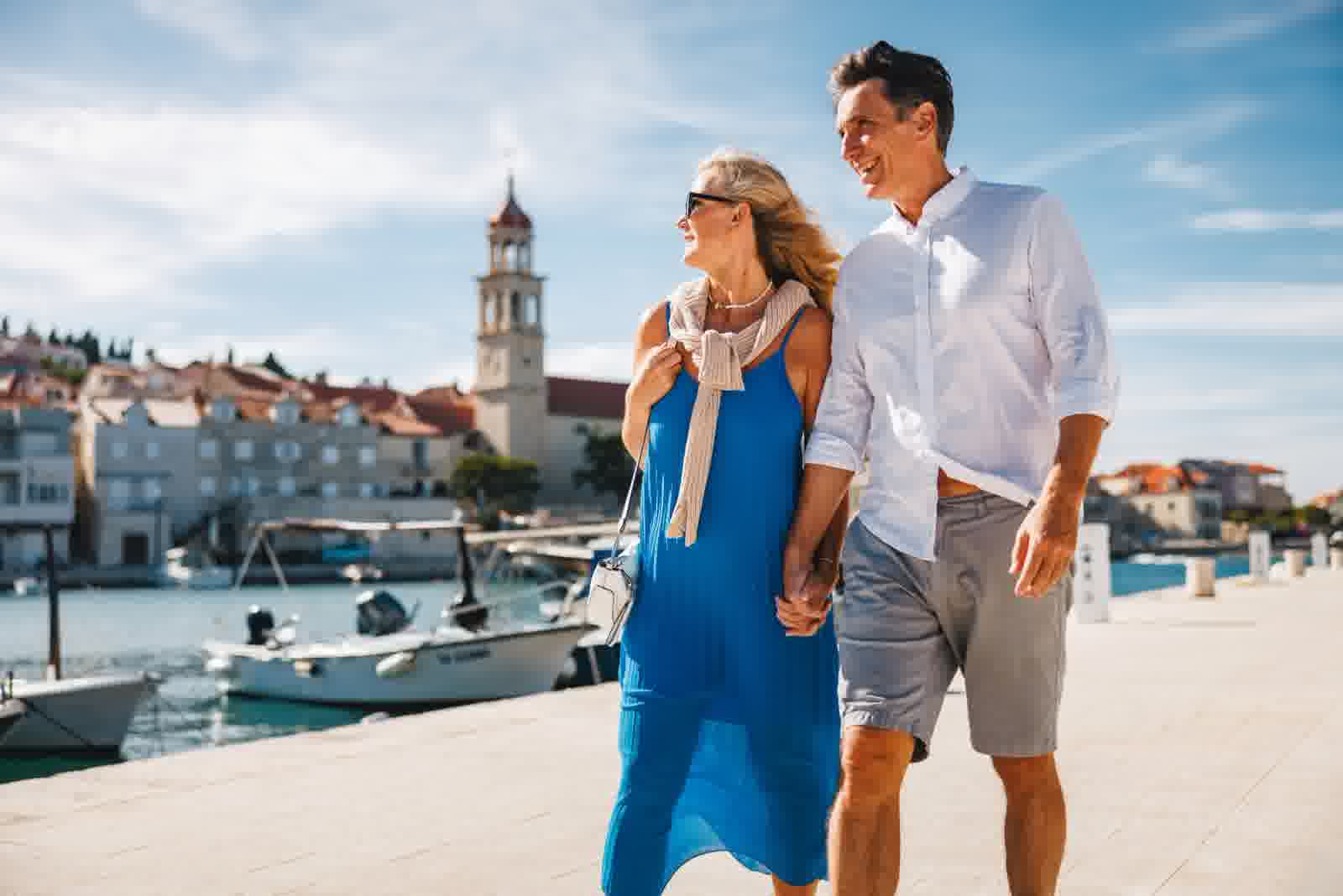 Happy couple walking by a harbor